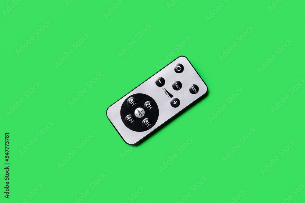 gray remote control on a green background