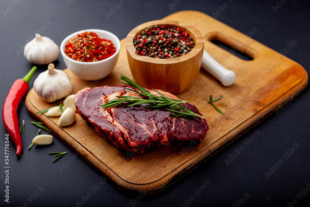 Fresh steak with a set of spices on a cutting board Fresh steak with a set of spices on a cutting board