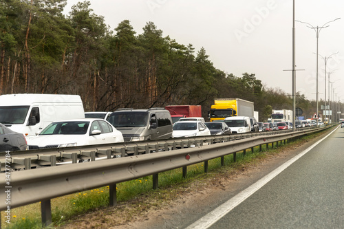 Highway interstate road with car traffic jam and tree forest on background. Motorway bumber barrier gridlock due country border control point. Vehicle crash accident and queue bottleneck on freeway
