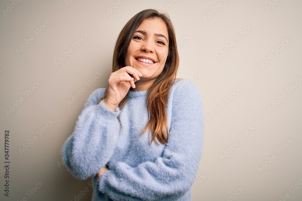 Beautiful young woman wearing casual winter sweater standing over isolated background looking confident at the camera with smile with crossed arms and hand raised on chin. Thinking positive. Beautiful young woman wearing casual winter sweater standing over isolated background looking confident at the camera with smile with crossed arms and hand raised on chin. Thinking positive.