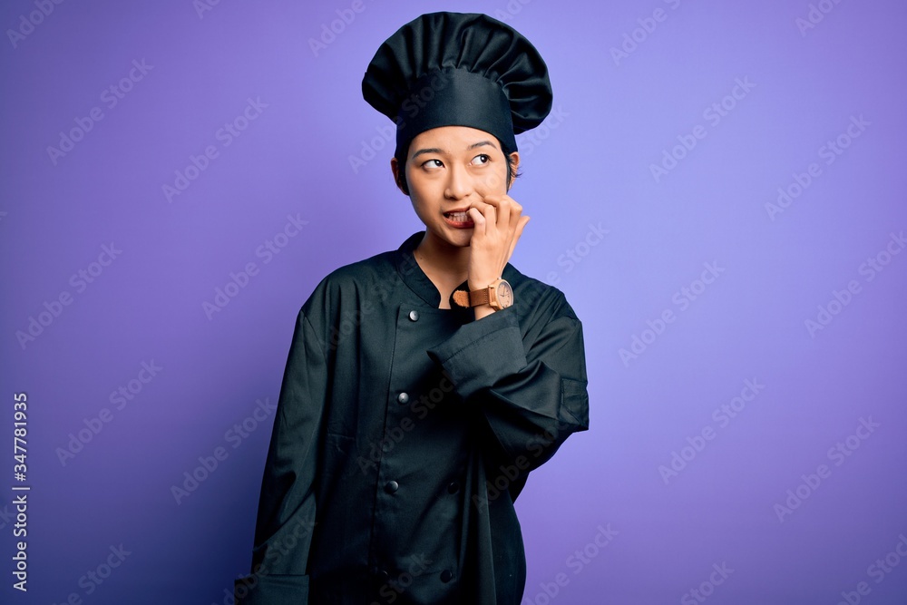Young beautiful chinese chef woman wearing cooker uniform and hat over purple background looking stressed and nervous with hands on mouth biting nails. Anxiety problem. Young beautiful chinese chef woman wearing cooker uniform and hat over purple background looking stressed and nervous with hands on mouth biting nails. Anxiety problem.