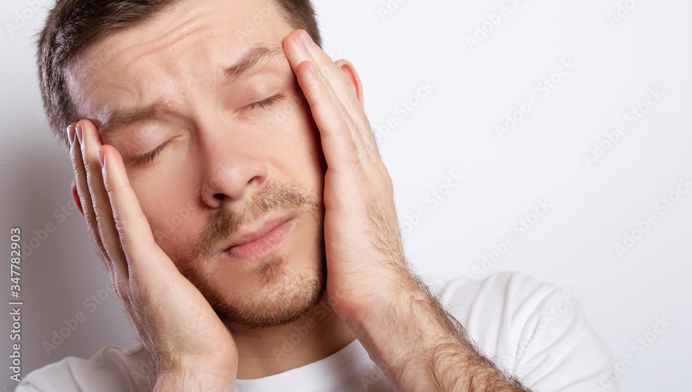 Man with fingers pressed to forehead, close-up Man with fingers pressed to forehead, close-up