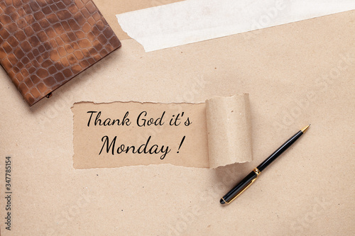 Kraft paper with a hole and words THANK GOD IT'S MONDAY, concept of happy work life. First Monday in January