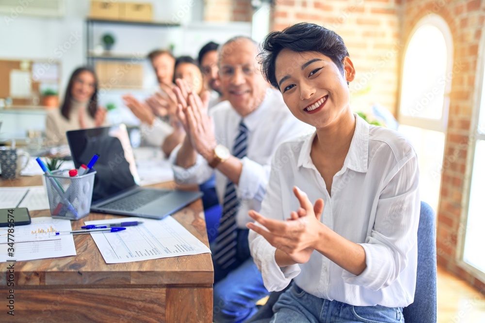Group of business workers smiling happy and confident. Working together with smile on face looking at the camera applauding at the office Group of business workers smiling happy and confident. Working together with smile on face looking at the camera applauding at the office