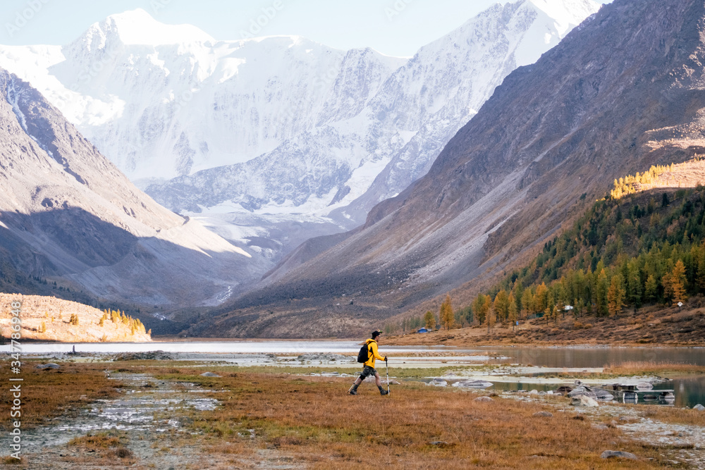 Man Traveler with backpack mountaineering in Altai mountain near Ak-Kem lake, Siberia, Russia. Travel Lifestyle concept.