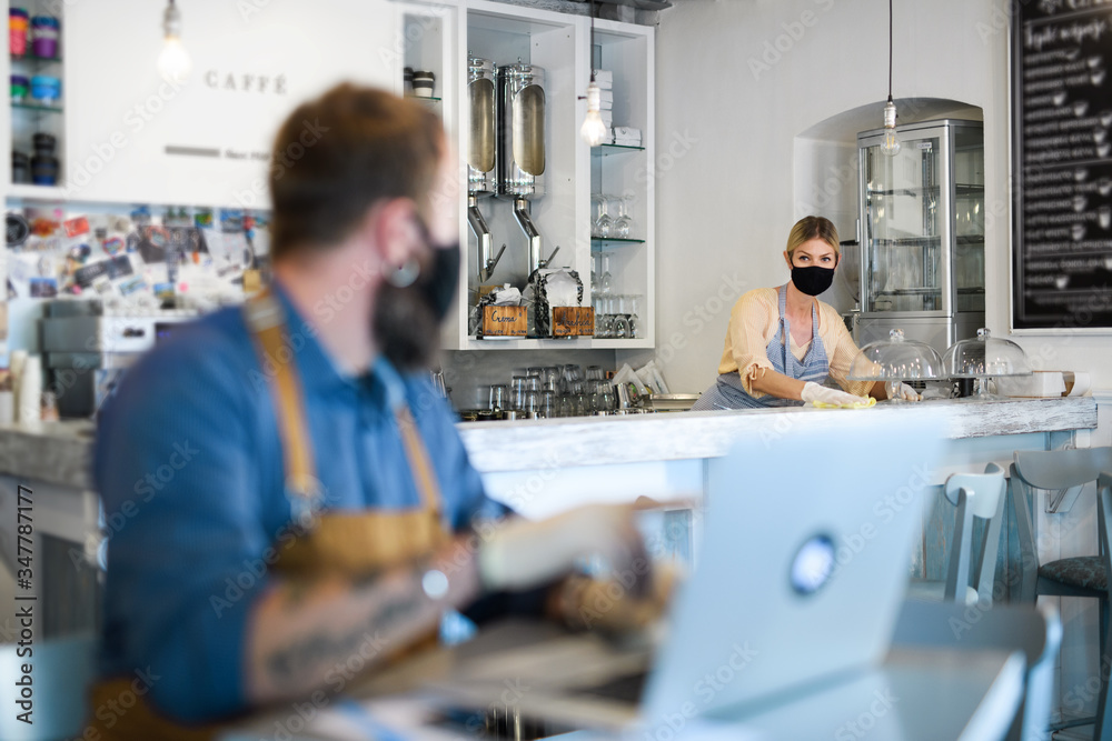 Coffee shop owners working with face masks, open after lockdown quarantine. Coffee shop owners working with face masks, open after lockdown quarantine.