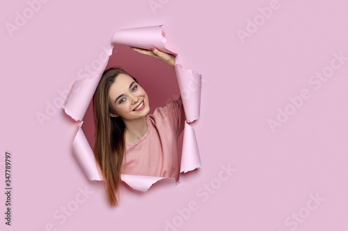 Portrait of beautiful joyful smiling caucasian woman posing in pink paper hole. copy space. banner for discounts and sales © producer