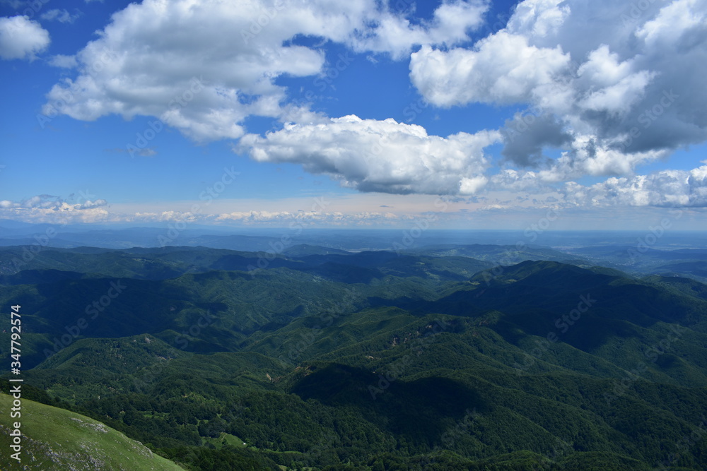 Obraz premium horizon seen from above in top of the mountain on summer day with white clouds and green grass