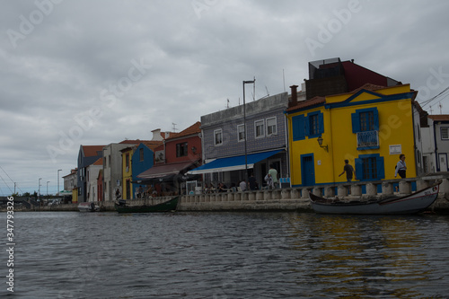cloudy day view of a canal with traditional colorful Moliceiro boats in Aveiro