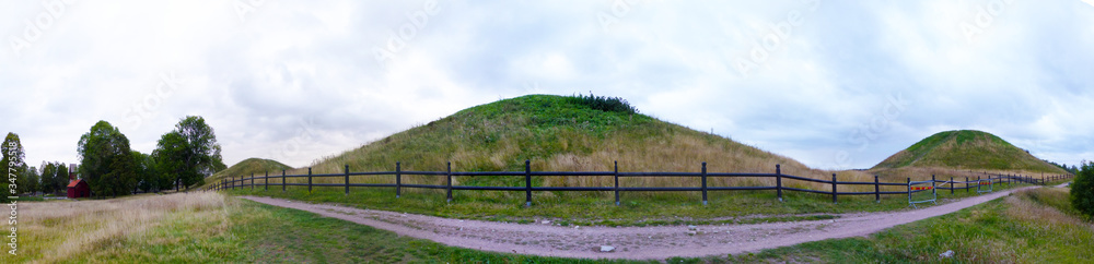 Panoramic view of Gamla Uppsala. The three large royal mounds. According to ancient mythology and folklore, the three gods Thor, Odin and Freyr. Sweden. Panoramic view of Gamla Uppsala. The three large royal mounds. According to ancient mythology and folklore, the three gods Thor, Odin and Freyr. Sweden.