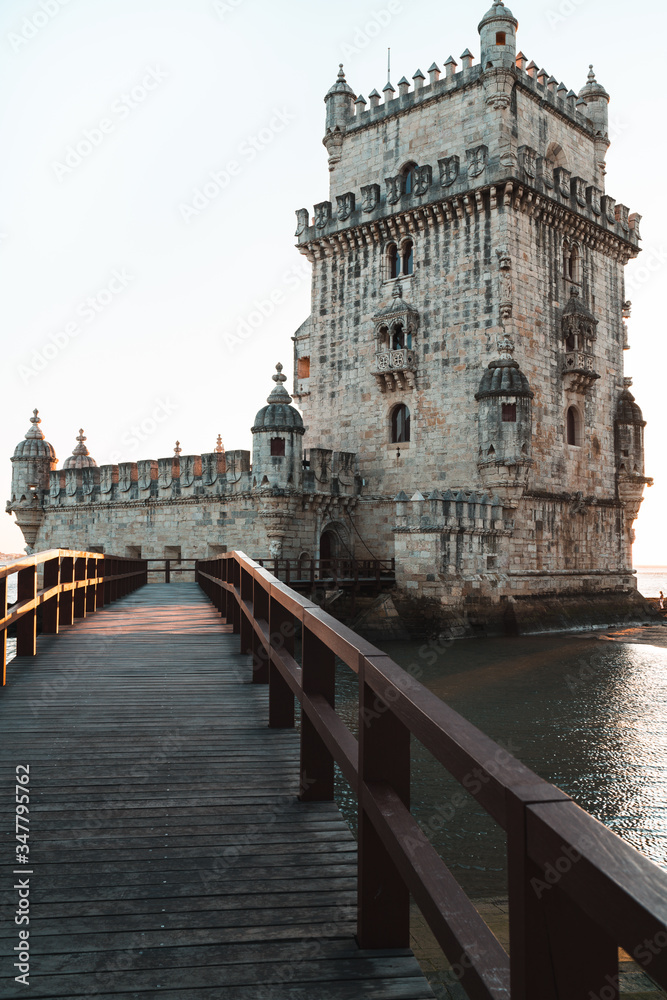 view of Belem Tower, Lisbon, wooden bridge at the entrance, shady side in the afternoon