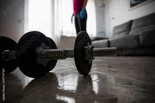 Girl doing sports with dumbbells at home