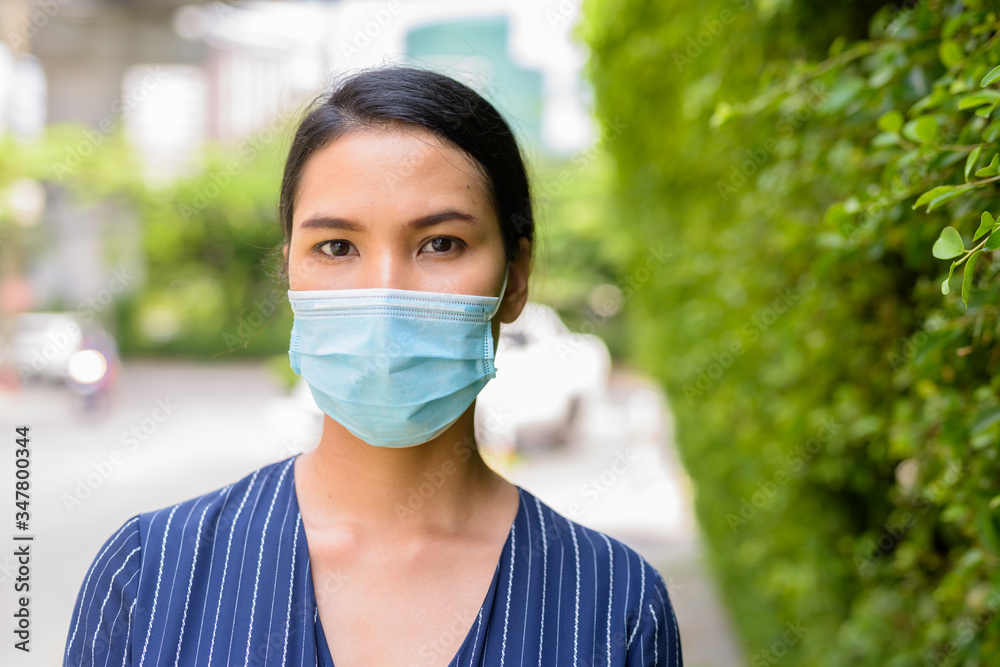 Φωτογραφία Face of young Asian businesswoman with mask for protection from corona virus out