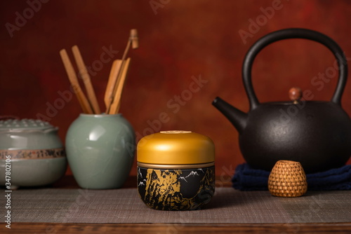 The tea ceremony is set against a wooden background.
