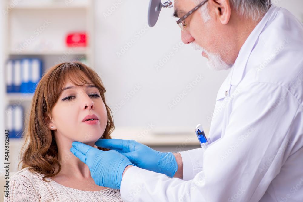 Young woman visiting old male doctor otorhinolaryngologist Young woman visiting old male doctor otorhinolaryngologist