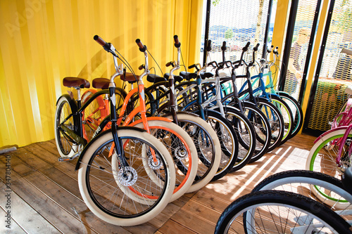 a lot of colored bikes model chopper in the city next to the yellow building in summer © Стефания Пипченко