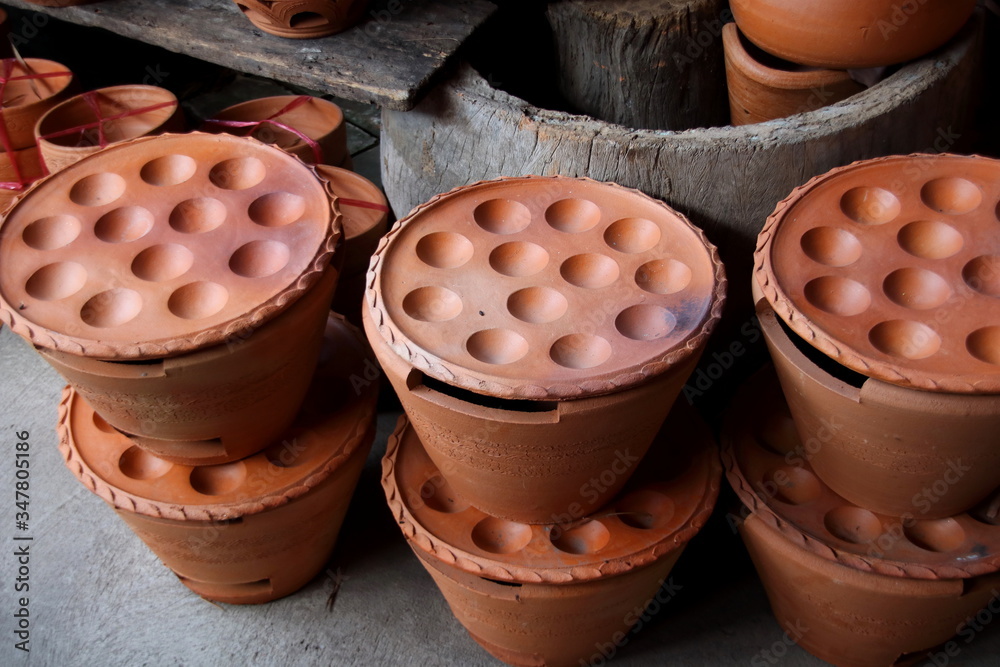 Kanom Krok pan set  made from clay are selling in shop, Thailand. Kamon Krok pan in retro style shape used for make Thai dessert  name is "Kanom Krok".  - obrazy, fototapety, plakaty 