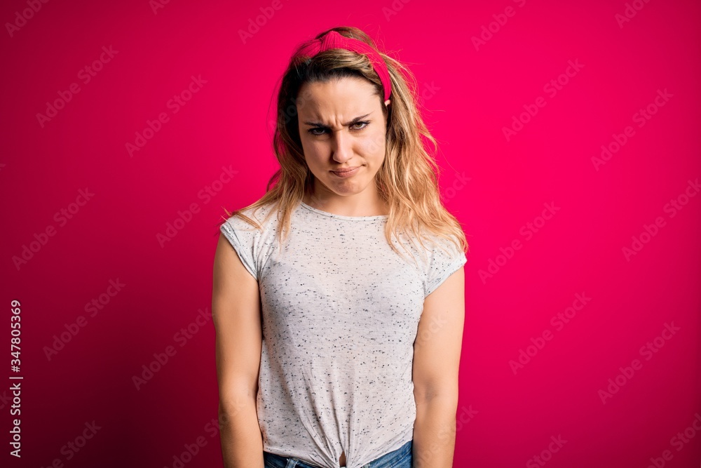 Young beautiful blonde woman wearing casual t-shirt standing over isolated pink background skeptic and nervous, frowning upset because of problem. Negative person. Young beautiful blonde woman wearing casual t-shirt standing over isolated pink background skeptic and nervous, frowning upset because of problem. Negative person.