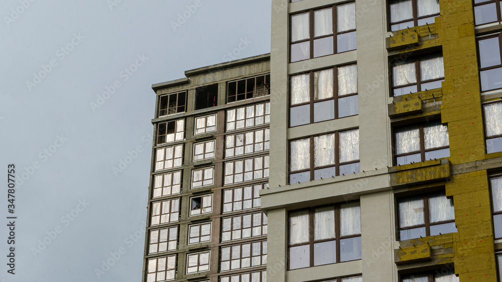 Obraz premium Modern apartment buildings on a gray day with a dramatic sky. Facade of a modern apartment building.
