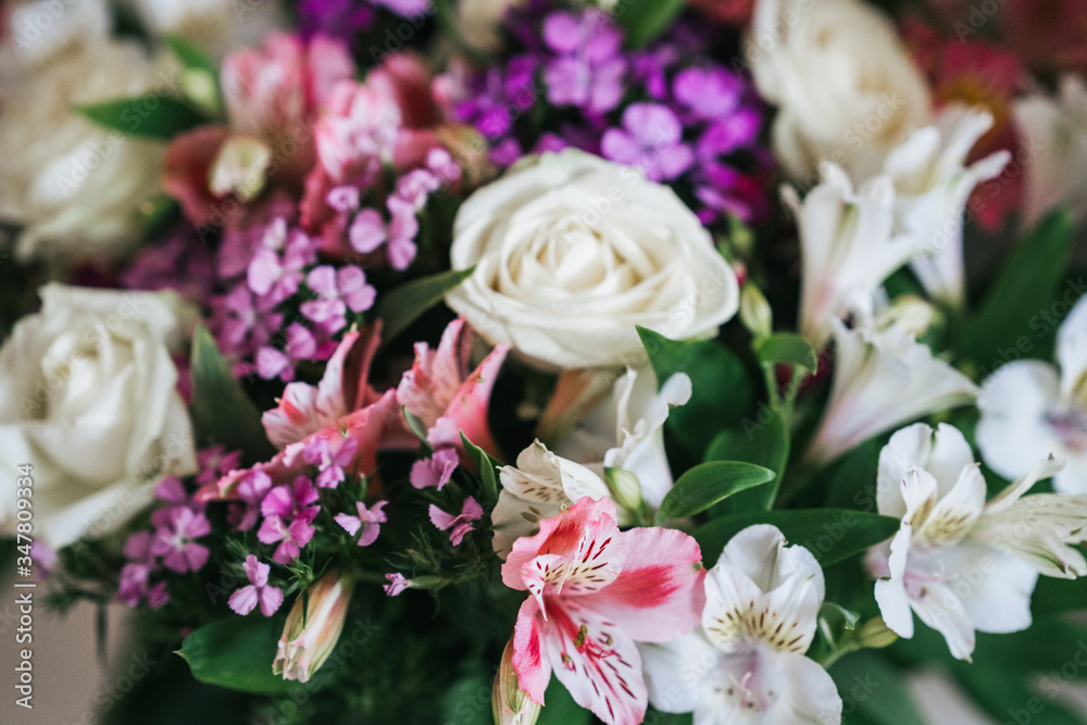 A bright, luxurious bouquet of colorful alstromeria and white roses. Photo with blurred background. A bright, luxurious bouquet of colorful alstromeria and white roses. Photo with blurred background.