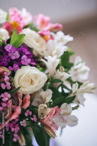 A bright  luxurious bouquet of colorful alstromeria and white roses. Photo with blurred background.