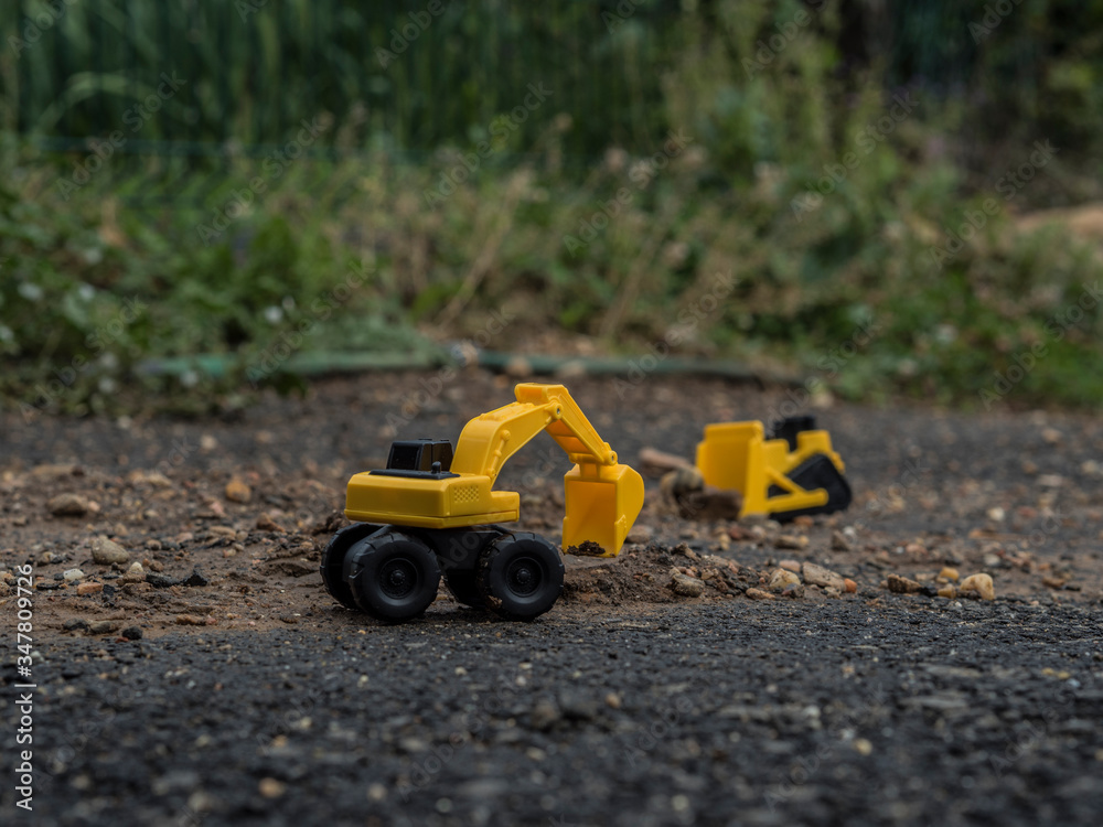 Toy construction machinery working on an excavation Toy construction machinery working on an excavation