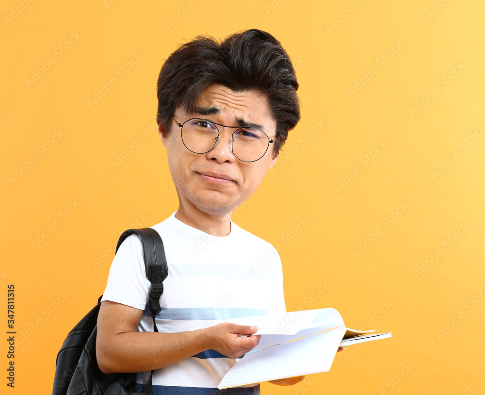 Stressed male Asian student with big head on color background Stressed male Asian student with big head on color background