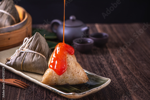 Zongzi - Chinese rice dumpling zongzi in a steamer on wooden table black retro background for Dragon Boat Festival celebration, close up, copy space. photo