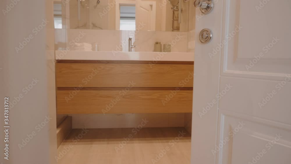 The camera moves slowly forward behind the opening door to the bathroom The camera moves slowly forward behind the opening door to the bathroom