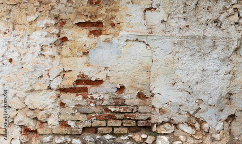 Old brick wall with damaged white lime. Textured surface for backgrounds.