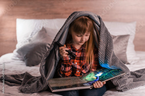 Young girl reading a book u...