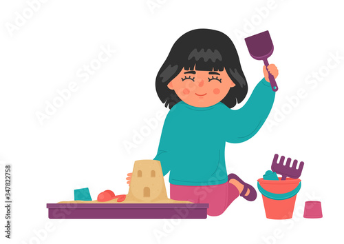 Kid plays with sand and toys in plastic sandbox. Cute little girl builds castle. Children sensory, motor skills, creativity and imagination development playing concept.
