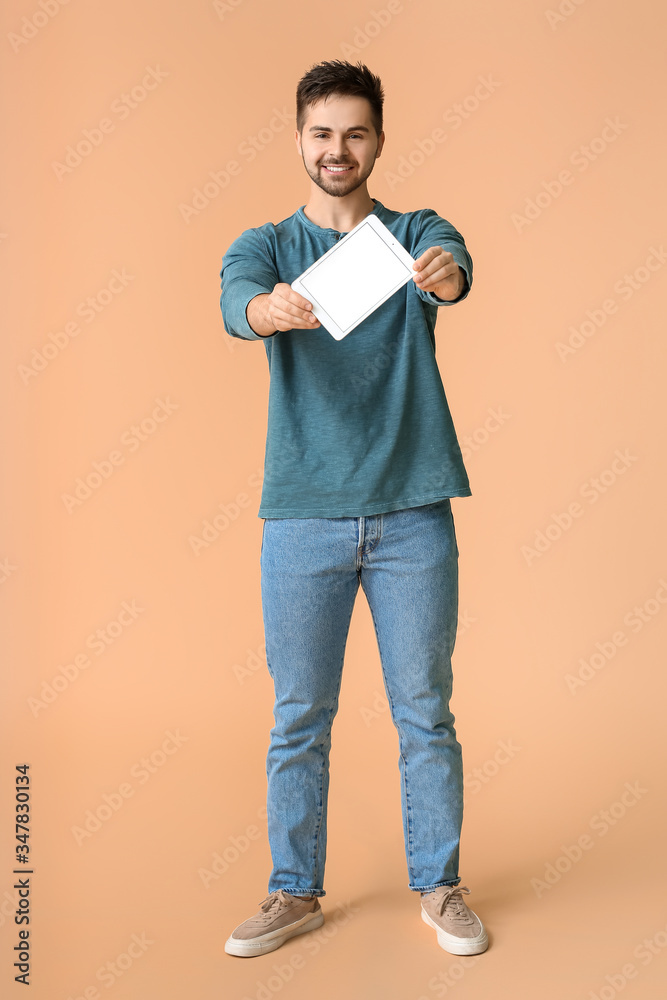 Young man with tablet computer on color background Young man with tablet computer on color background