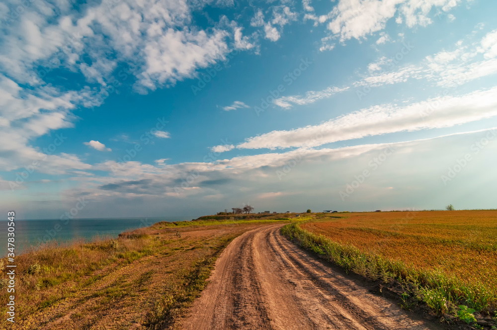 Dirt road in the field near sea coast.