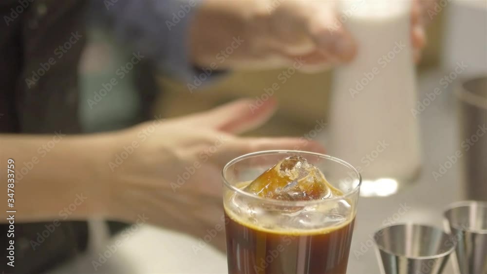 woman picking up ice with tongs then pour milk - static woman picking up ice with tongs then pour milk - static