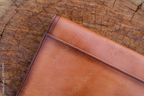 Brown leather wallet on wood texture.