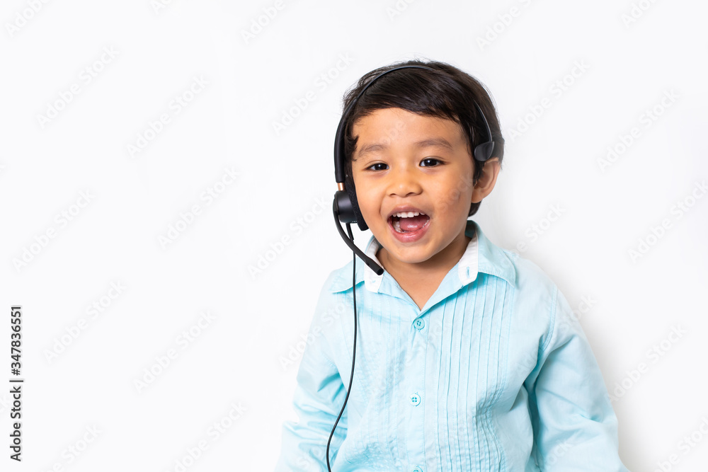 Child as a businessman in a video conference. Cute Asian boy in VOIP Helpdesk headset. Kid customer service center. Kid education and e-learning concept. Child as a businessman in a video conference. Cute Asian boy in VOIP Helpdesk headset. Kid customer service center. Kid education and e-learning concept.