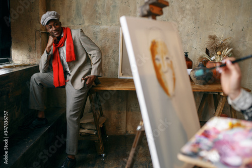 Canvas-taulu Female painter with brush draws male model