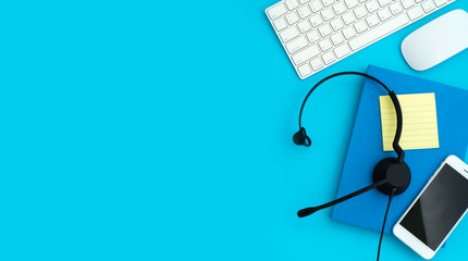 VOIP Helpdesk headset, keyboard computer notebook and mouse isolated on blue background. Communication support for callcenter and customer service Helpdesk