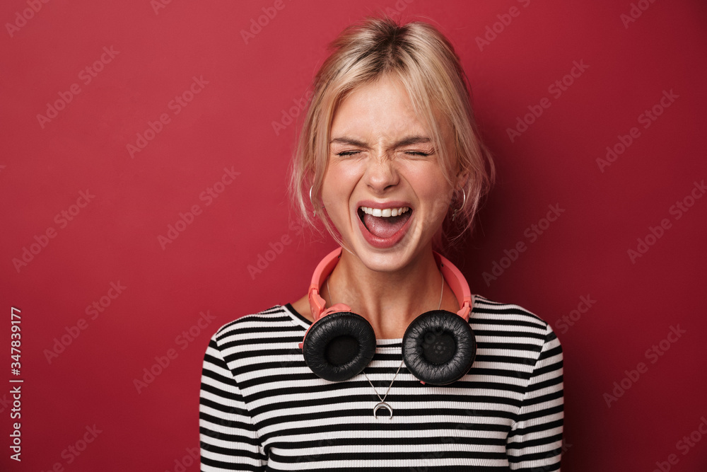 Fototapeta premium Image of nice excited woman with headphones screaming at camera