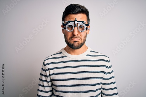 Young handsome man with beard wearing optometry glasses over isolated white background depressed and worry for distress, crying angry and afraid. Sad expression. © Krakenimages.com