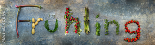 Frühling, Wort geschrieben aus Gemüse und Obst, Erdbeeren, Radieschen, Bärlauch, Waldmeister, grüner Spargel, Babyspinat, Rhabarber, neue Kartoffeln