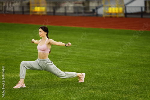 Attractive woman in sportswear doing stretching outdoor