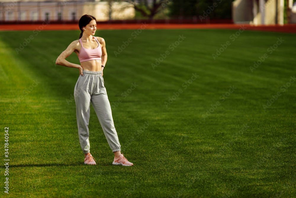Attractive young fitness woman in sportswear traning outdoor
