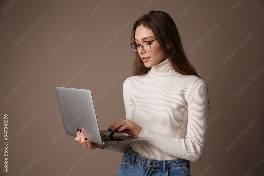 Photo of focused beautiful woman holding and using laptop Photo of focused beautiful woman holding and using laptop