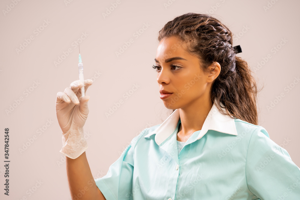 Portrait of young nurse who is holding syringe. Portrait of young nurse who is holding syringe.