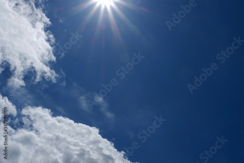 Blue sky background with Stratocumulus clouds and sunbeams. Copy space  place for text.