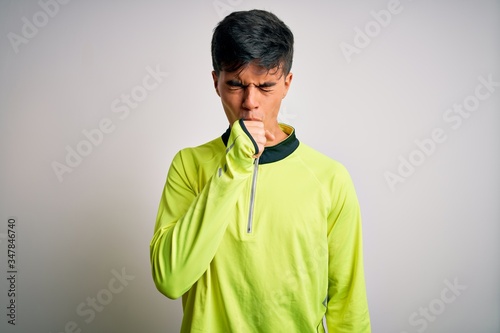 Young handsome sportsman doing sport wearing sportswear over isolated white background feeling unwell and coughing as symptom for cold or bronchitis. Health care concept.