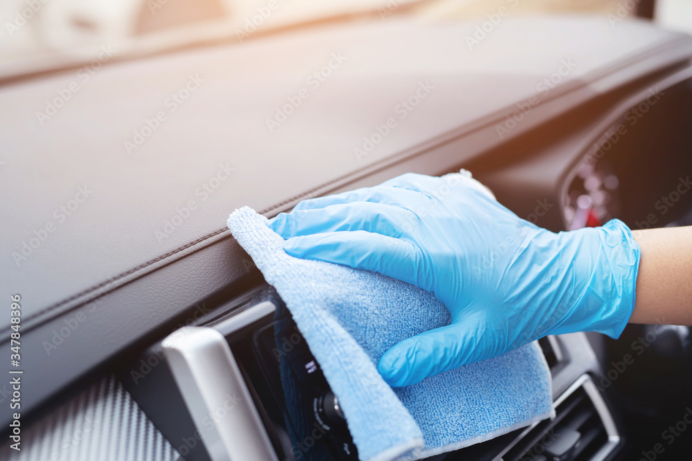 worker man wear gloves cleaning car interior console with microfiber cloth, detailing, car wash service concept. copy space.