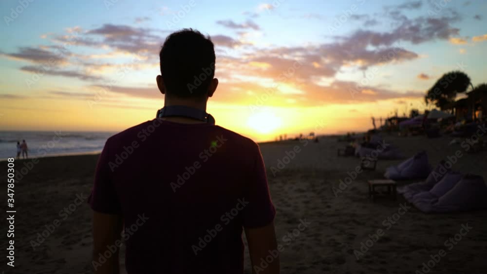 Silhouette of young man admire, enjoying beautiful sunset on the beach Silhouette of young man admire, enjoying beautiful sunset on the beach